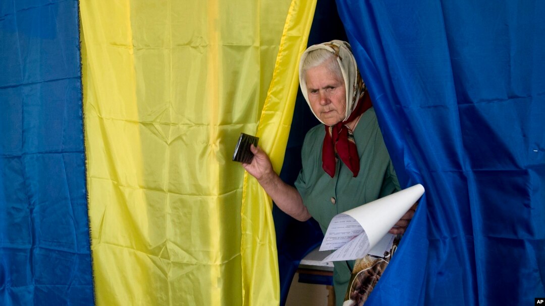 Seorang perempuan keluar dari bilik setelah memberikan suaranya dalam pemilihan presiden di Krasnoarmiisk timur, Ukraina, Minggu, 25 Mei 2014.