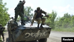 A Ukrainian serviceman jumps from an armoured personnel carrier (APC) in Avdeyevka near Donetsk, Ukraine, June 4, 2015. 