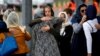 People embrace as they attend the burial ceremony of the victims of the mosque attacks, at the Memorial Park Cemetery in Christchurch, New Zealand, March 21, 2019.