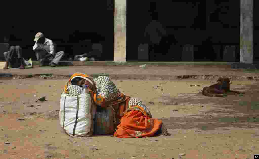 An attendant of a patient suspected of swine flu virus rests on the ground in the premises of the Gandhi Hospital in Hyderabad, India. According to local reports, nine people died of the flu at the state-run hospital.