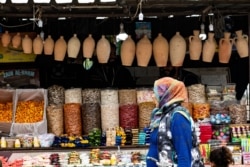 FILE - A woman walks through a market in the Kurdish-majority city of Qamishli, in Syria's northeastern Hasakeh province, Oct. 29, 2019.