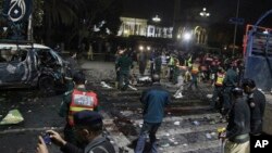 Polisi dan petugas keamanan memagar betis lokasi terjadinya pemboman mematikan di Lahore, Pakistan, Senin, 13 Februari, 2017. (AP Photo/K.M. Chaudhry)