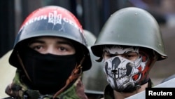 Manifestantes antigubernamentales vigilan una barricada en Kiev. El gobierno y los manifestantes parecen haber llegado a un acuerdo.