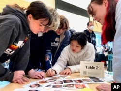 Ballard High School students work together to solve an exercise at MisinfoDay, an event hosted by the University of Washington to help high school students identify and avoid misinformation, Tuesday, March 14, 2023, in Seattle. (AP Photo/Manuel Valdes)