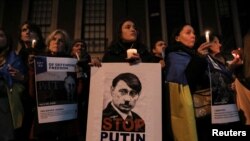 Учасники протесту з плакатом 'Stop Putin' біля посольства РФ у Нью-Йорку, США, 23 лютого 2023 р. REUTERS/Irynka Hromotska