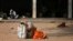 FILE - An Indian attendant of a patient suspected with swine flu virus rests on the ground in the premises of Gandhi Hospital in Hyderabad, India, Wednesday, Jan. 21, 2015. According to local reports, nine people died of the flu at the state-run hospital. 