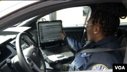 La oficial de policía del condado Arlington, Patrice Malone,revisa su computadora a bordo de su patrulla.