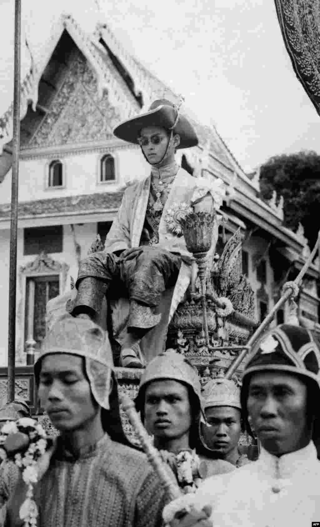 King Bhumibol Adulyadej of Thailand, Rama IX, is carried by a cortege during the Coronation ceremony, May 5, 1950.