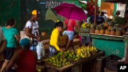 FILE - People shop at the El Egido food market in Havana, Cuba. Cuban state-run media reported on April 13, 2016 that Cuba will open its state-controlled wholesale market to a limited number of private business owners in response to rising food prices that may have angered many ordinary Cubans.