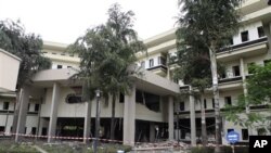 Debris and security tape surround the Nigerian headquarters of the United Nations one day after a suicide bomber crashed through an exit gate and into the reception area detonating a car full of explosives, in Abuja, Nigeria Saturday.