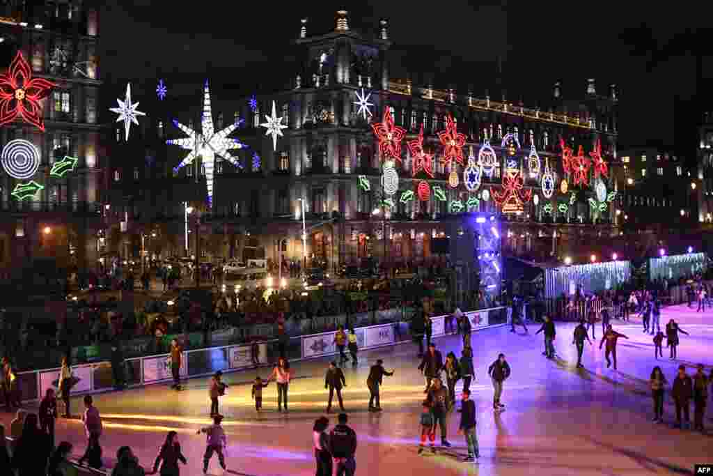 People skate on an plastic rink placed in the Zocalo square with the City Hall showing Christmas decorations,&nbsp; in Mexico City, Dec. 17, 2019.