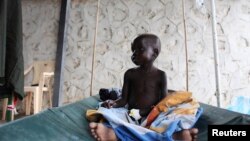 A South Sudanese child suffering from cholera sits on a bed in Juba Teaching Hospital, May 27, 2014. China has pledged $33 million to renovate the hospital. 