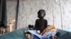 A South Sudanese child suffering from cholera sits on a bed in Juba Teaching Hospital, May 27, 2014. China has pledged $33 million to renovate the hospital. 