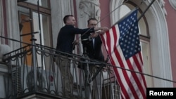 Employees take down the U.S. flag on the U.S. Consulate General in St. Petersburg, Russia, March 31, 2018.