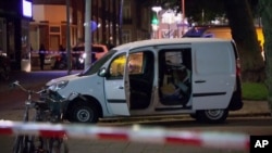 In this image taken from video, a van is examined behind a cordoned-off area in Rotterdam, Aug. 23, 2017, after a possible terror threat resulted in the cancellation of a concert by an American band. Police detained the driver of a van with Spanish license plates carrying a number of gas tanks inside.