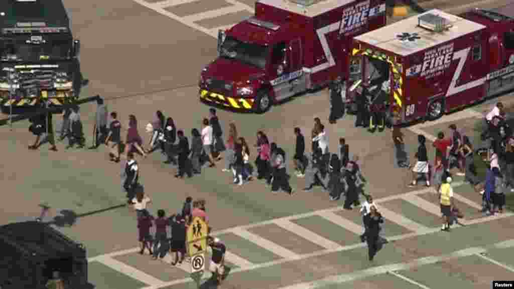 Students are evacuated from Marjory Stoneman Douglas High School during a shooting incident in Parkland, Feb. 14, 2018 in a still image from video.