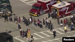 Students are evacuated from Marjory Stoneman Douglas High School during a shooting incident in Parkland, Florida, Feb. 14, 2018 in a still image from video.