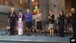 缅甸反对派领导人昂山素季(左2)2012年6月16 日在奥斯陆市政厅发表发表1991年诺贝尔和平奖获奖演说前在讲台上接受挪威诺贝尔奖委员会起立鼓掌