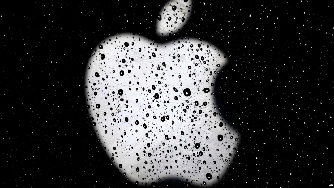 ARSIP – Logo Apple tampak di balik jendela yang diselimuti butir-butir air hujan di luar Apple Store di distrik perbelanjaan Country Club Plaza di Kansas City, 26 Desember 2018 (foto: AP Photo/Charlie Riedel, Arsip)