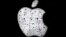 ARSIP – Logo Apple tampak di balik jendela yang diselimuti butir-butir air hujan di luar Apple Store di distrik perbelanjaan Country Club Plaza di Kansas City, 26 Desember 2018 (foto: AP Photo/Charlie Riedel, Arsip)