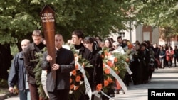 FILE - A funeral procession on April 13, 1999, leads the coffin of prominent Serbian opposition journalist Slavko Curuvija, owner of the daily Dnevni Telegraf, who was killed in Belgrade two days earlier.