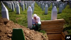 Një grua në Bosnjë kryen ritet fetare pranë varrit të një të afërmi të saj në Qendrën Përkujtimore të Srebrenicës, në Potoçari, më 11 korrik, 2024/AP