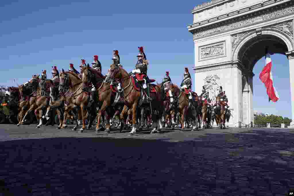 法国首都巴黎的国庆游行中，共和国卫队骑马走过巴黎凯旋门。庆祝活动包括大规模游行，由法军部队、军乐队以及美国喷气式战斗机的空中展示组成。 今年法国国庆日的庆祝活动与美国加入第一次世界大战100周年的纪念日合并在一起庆祝。 这次阅兵由美军走在队伍前列，美国总统川普是贵宾（2017年7月14日）
