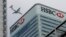 FILE - An aircraft flies past the HSBC headquarters building in the Canary Wharf financial district in east London, Feb. 15, 2015. 