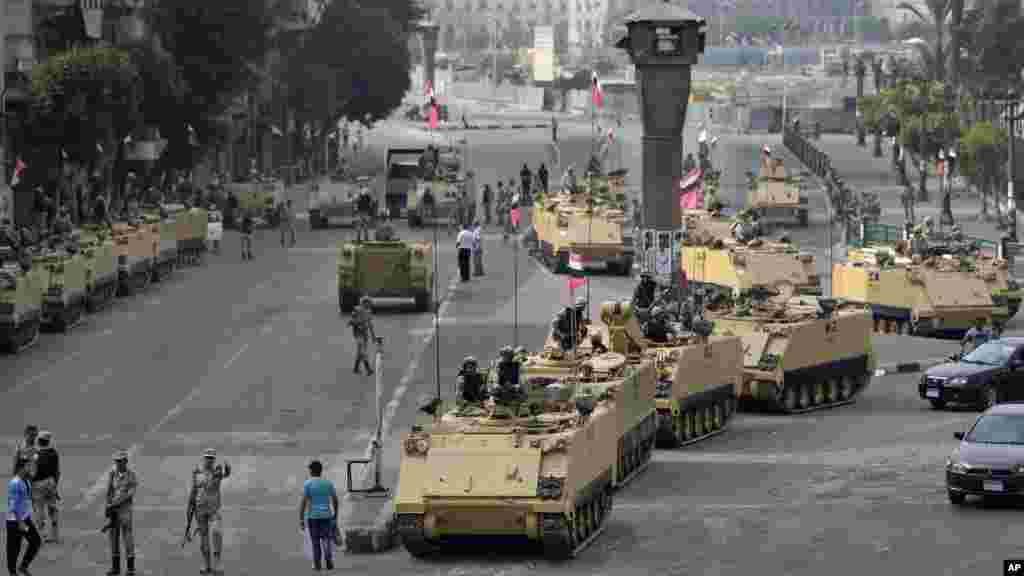 Egyptian army soldiers take their positions on top and next to their armored vehicles while guarding an entrance to Tahrir square, in Cairo, Egypt, Friday, Aug. 16, 2013. 