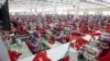 FILE - Garment workers sew clothes in a factory outside Phnom Penh, Cambodia, Aug. 30, 2017. A new government initiative now makes available to them free legal services to help settle disputes with employers. But some see the offer as hollow.