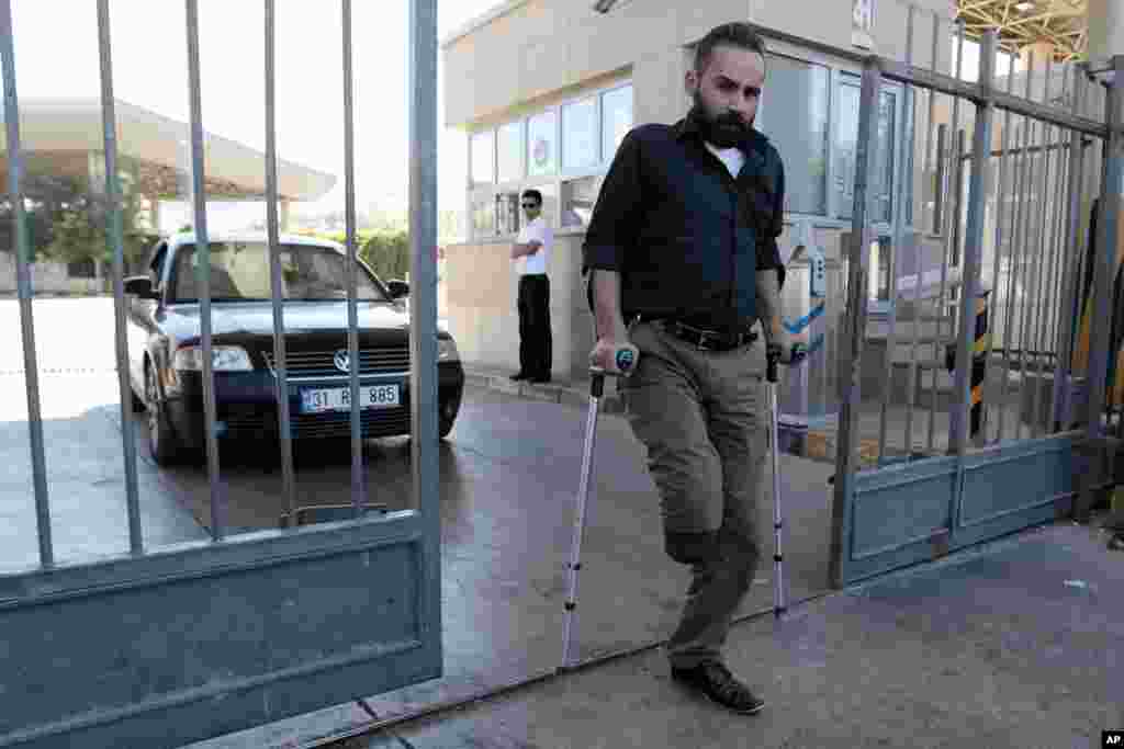 A Syrian refugees uses crutches as he passes through the Turkish Cilvegozu gate border, Sept. 11, 2013.