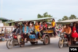 ក្រុមកម្មកររោងចក្រ​ ធ្វើដំណើរ​ទៅផ្ទះ​ ក្រោយ​ចេញ​ពី​ធ្វើការ​ នៅ​ពេល​ល្ងាចមួយ ឯ​ជាយ​រាជធានី​ភ្នំពេញ​ នៅថ្ងៃទី២៥​ ខែ​ឧសភា​ ឆ្នាំ​២០១៧។ (ខាន់ សុគុំមនោ/VOA)