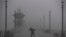 A man struggles against gusty wind and heavy rain as he walks along a pier in Huntington Beach, Calif., Feb. 17, 2017. A major Pacific storm has unleashed downpours and fierce gusts on Southern California, triggering flash flood warnings and other problem