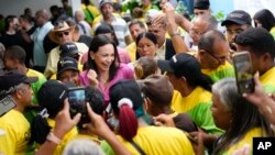 La candidata presidencial opositora María Corina Machado saluda a simpatizantes durante una conferencia de prensa donde el partido Convergencia le expresó su apoyo en la primaria de octubre, en Caracas, este miércoles 6 de septiembre de 2023.