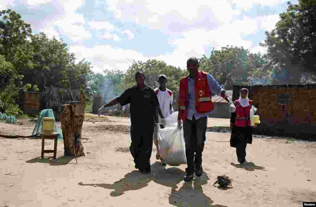 Members of the Kenyan Red Cross carry the body of a man killed during an attack in Kibusu village in the Tana Delta region of Kenya, January 10, 2013. 