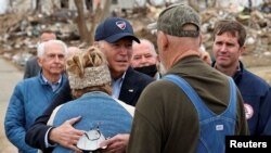 Presiden AS Joe Biden memeluk seorang warga yang terdampak tornado di Dawson Springs, Kentucky, dalam kunjungannya pada 15 Desember 2021. (Foto: Reuters/Evelyn Hockstein)