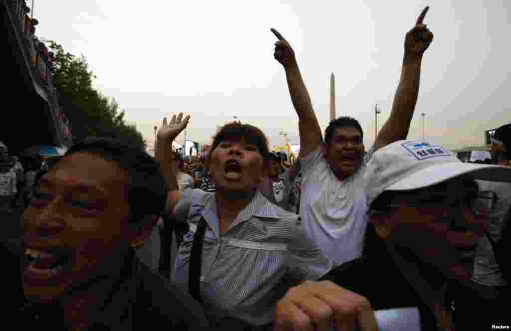 Para demonstran anti-kudeta mengolok-olok polisi anti-huru-hara dalam sebuah protes melawan kekuasaan militer di Monumen Kemenangan di Bangkok (26/5).