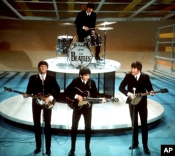 FILE -The Beatles, foreground from left, Paul McCartney, George Harrison, John Lennon and Ringo Starr on drums perform on the CBS "Ed Sullivan Show" in New York on Feb. 9, 1964. A “new” Beatles song.“Now And Then,” will be available Thursday, Nov. 2. (AP Photo/File)