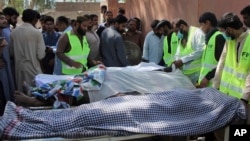 Pakistani volunteers and local residents gather around the bodies of people who were killed in a local shrine, outside the morgue of a hospital in Sarghodha, Pakistan, April 2, 2017.