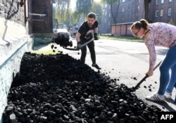 Seorang penambang batubara dan istrinya memasukkan batubara ke dalam ruang bawah di rumahnya di Mikolow, di Silesia, daerah pertambangan di selatan Poland, 12 Oktober 2018.