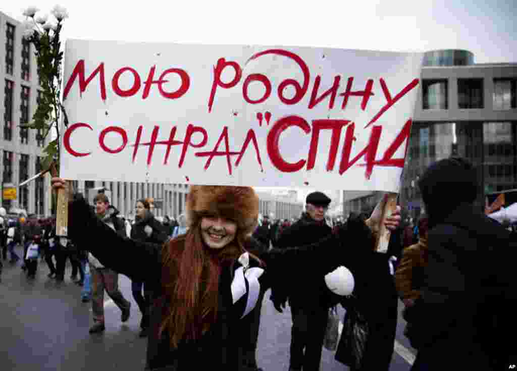 A protester holds a sign that reads, "My motherland was devoured by AIDS." In a recent televised Q & A Prime Minister Vladmir Putin joked that the protesters white ribbons looked like condoms. Protesters in turn said the condom were a means of protection 