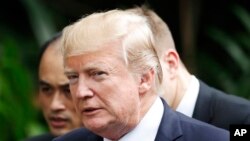 U.S. President Donald Trump, right, and Russia's President Vladimir Putin, center, talk during a group photo session at the APEC Summit in Danang, Nov. 11, 2017.