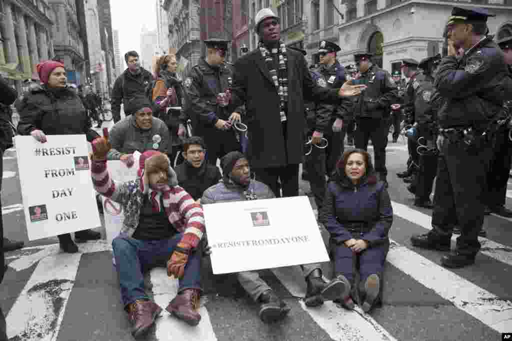 Police officers prepare to take New York City Councilman Jumaane Williams, center, into custody after he and others blocked traffic on Fifth Avenue outside Trump Tower in New York, Friday, Jan. 20, 2017, during a protest during President Donald Trump&#39;s inauguration. (AP Photo/Mary Altaffer)