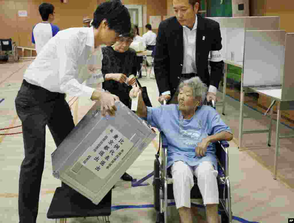 An elderly woman casts her vote in Japan's upper house parliamentary elections at a polling station in Tokyo, July 21, 2013.