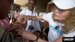 UNICEF Goodwill Ambassador Mia Farrow gives a child a dose of vitamin A, to help boost immunity, during a UNICEF-sponsored immunization at the Majengo health center in Goma, capital of North Kivu Province.