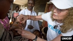 UNICEF Goodwill Ambassador Mia Farrow gives a child a dose of vitamin A, to help boost immunity, during a UNICEF-sponsored immunization at the Majengo health center in Goma, capital of North Kivu Province. 