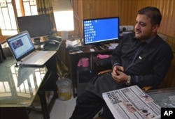 FILE - Journalist Zafar Achakzai, who was held for sharing content criticizing security forces on social media, sits in his office after being released from jail, in Quetta, Pakistan, July 9, 2017.