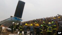 Rescatistas nepaleses trabajan entre los escombros después de que un avión de pasajeros se estrelló en el aeropuerto de Katmandú, Nepal, el lunes, 12 de marzo de 2018.