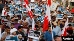 Anti-government protesters holding Bahraini flags and signs saying "No To Official Terror" march during a rally organized by Bahrain's main opposition party Al Wefaq on Budaiya highway west of Manama, August 23, 3013.