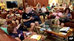 FILE - Community activists learn how to register voters on their phones at a democratic Stand Indivisible AZ monthly meeting in Scottsdale, Ariz., as they strategize about upcoming mid term elections, July 16, 2018.